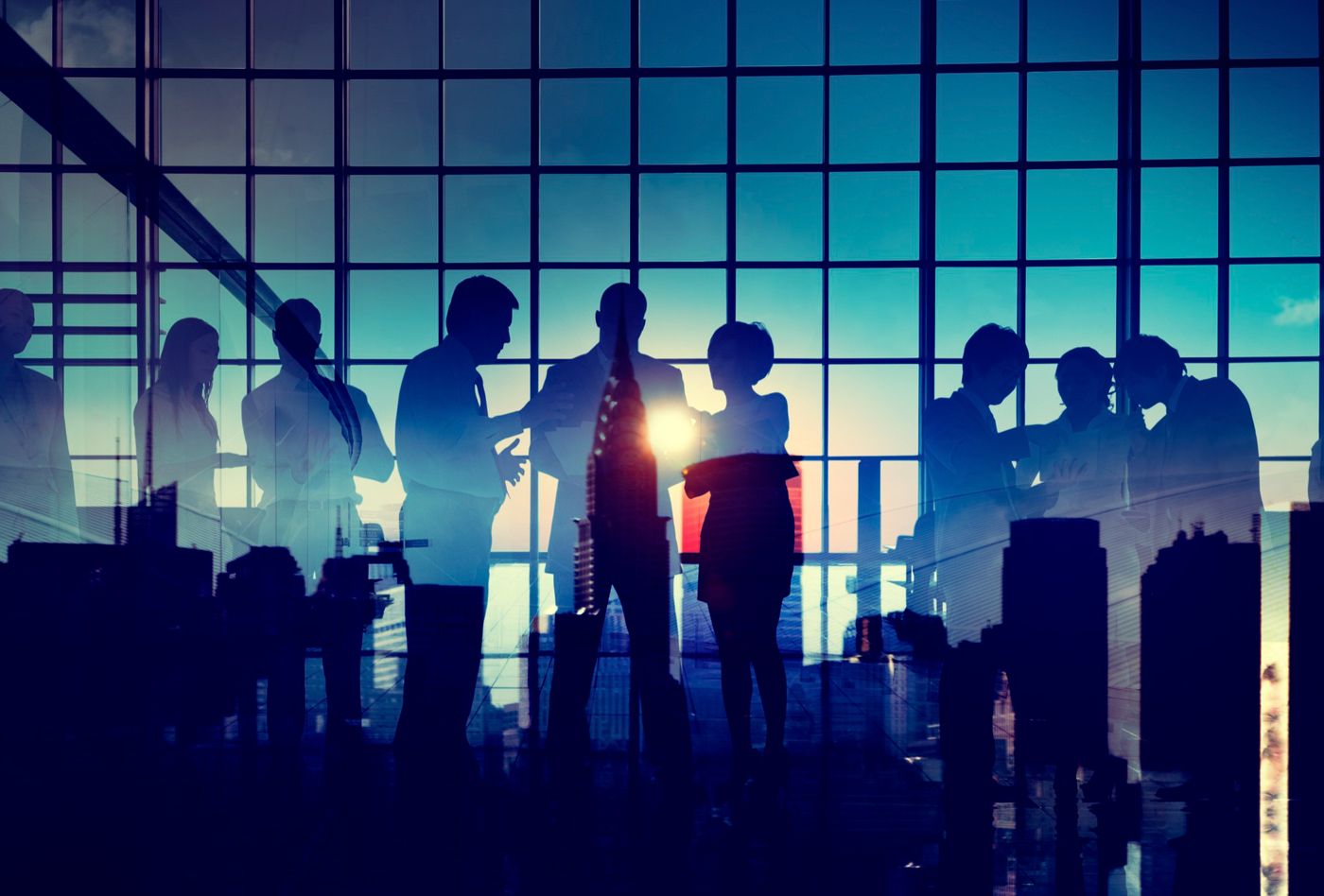 A programme team in discussion against a city skyline at dusk